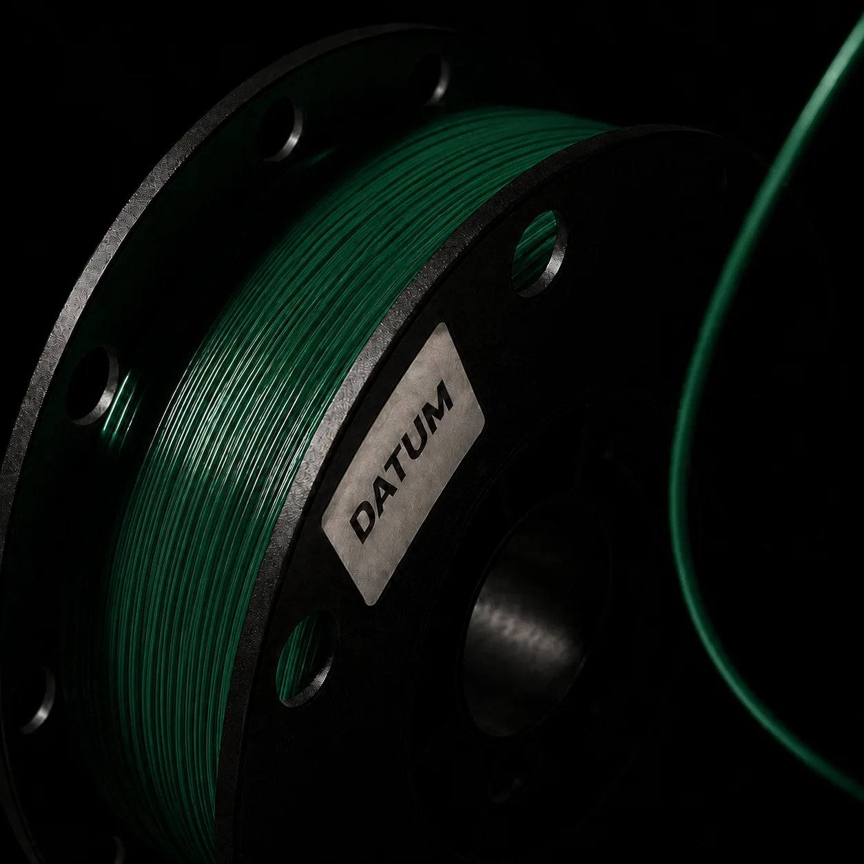 The same spool in Brunswick, a dark green that only shows its winding where the raking light catches it.